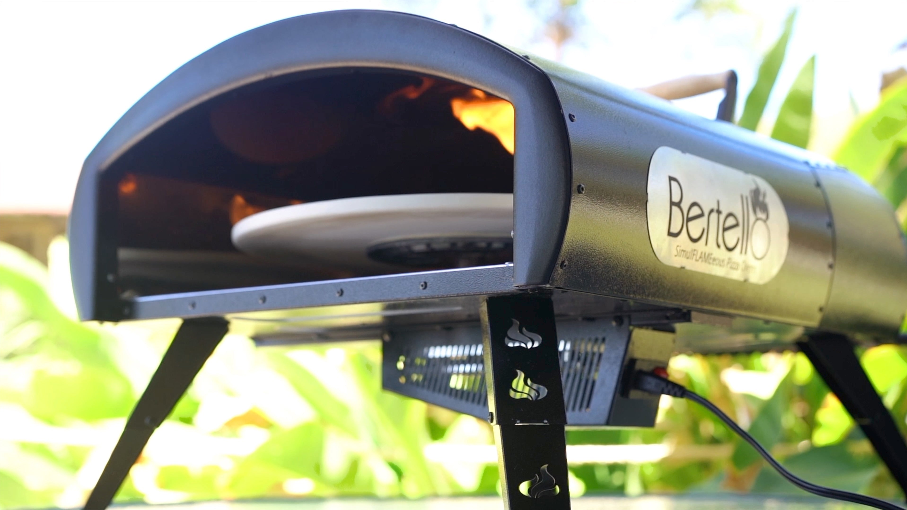 Bertello SimulFIRE 16-inch Rotating Outdoor Pizza Oven, exact U.S. SKUROTATE, shown with open cooking chamber, rotating stone, burner flame and cord
